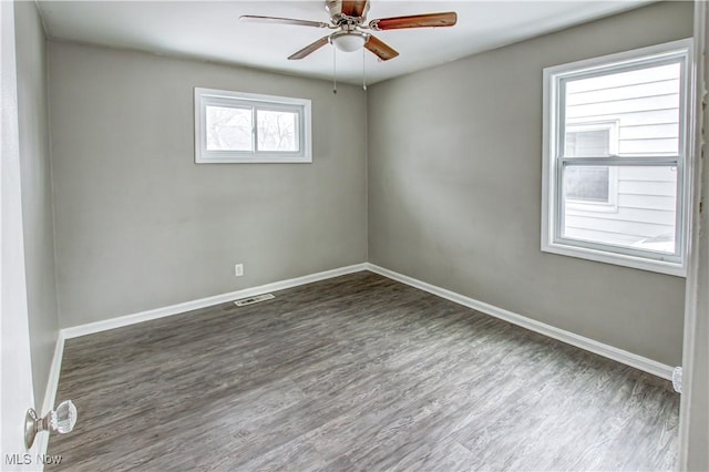 unfurnished room featuring ceiling fan, wood finished floors, visible vents, and baseboards