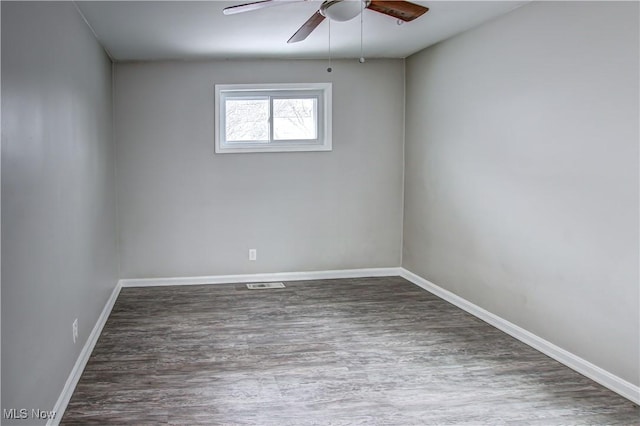 empty room featuring visible vents, baseboards, and wood finished floors