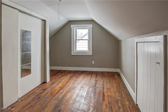 bonus room featuring lofted ceiling, hardwood / wood-style flooring, and baseboards