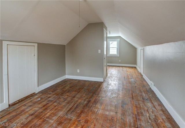 additional living space featuring lofted ceiling, hardwood / wood-style flooring, and baseboards