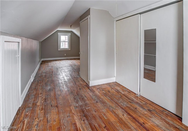 additional living space featuring lofted ceiling, wood-type flooring, and baseboards