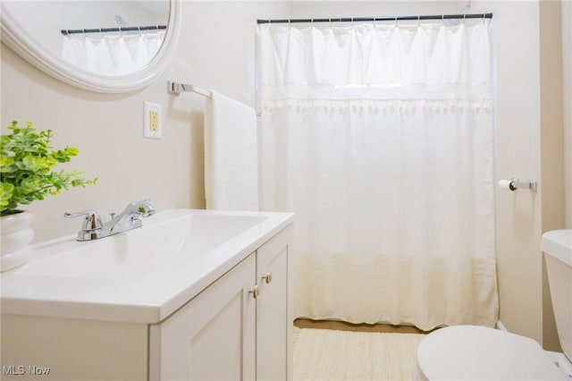 bathroom featuring toilet, a shower with curtain, and vanity