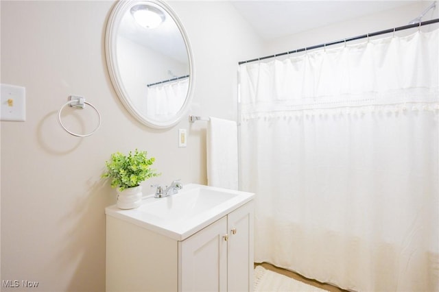 bathroom with curtained shower and vanity