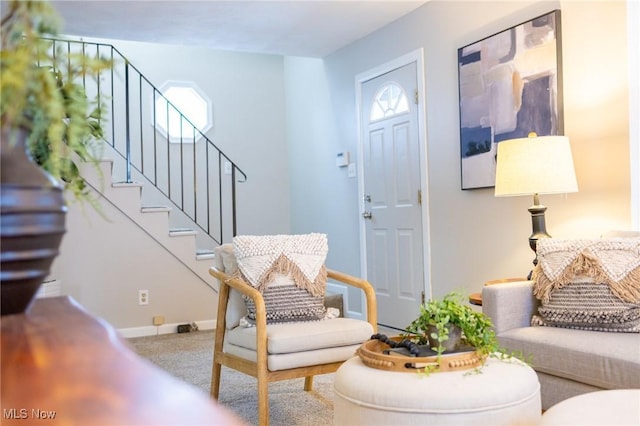 carpeted foyer entrance with stairway and baseboards