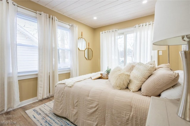 bedroom with multiple windows, wooden ceiling, wood finished floors, and recessed lighting