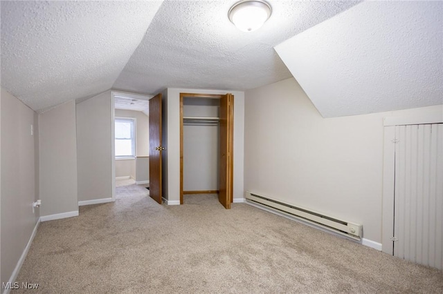 bonus room featuring a baseboard heating unit, carpet, vaulted ceiling, and baseboards