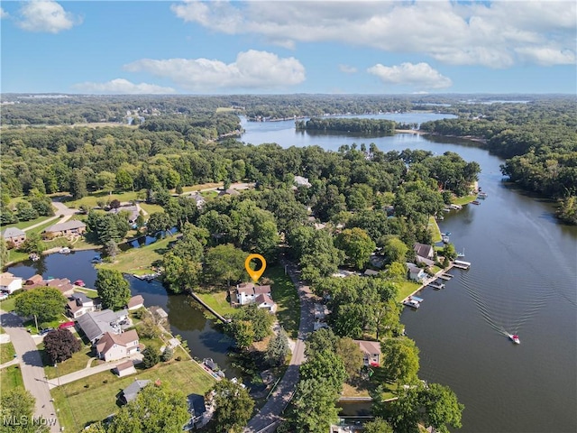 birds eye view of property with a water view and a wooded view