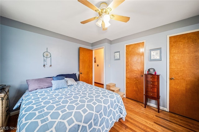 bedroom with ceiling fan, baseboards, and wood finished floors