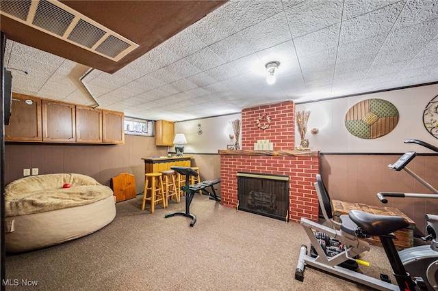 exercise room featuring a wainscoted wall, visible vents, and a fireplace