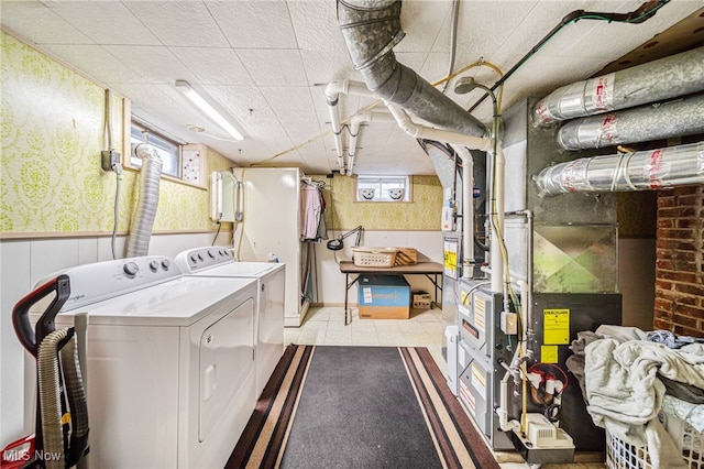 laundry area with laundry area, washer and clothes dryer, and wainscoting