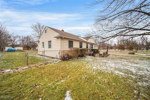 view of property exterior featuring a shingled roof, brick siding, fence, and a lawn