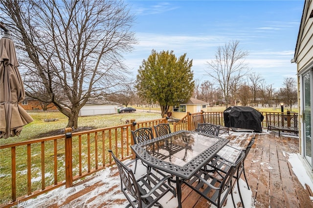 deck with outdoor dining area, grilling area, and a lawn