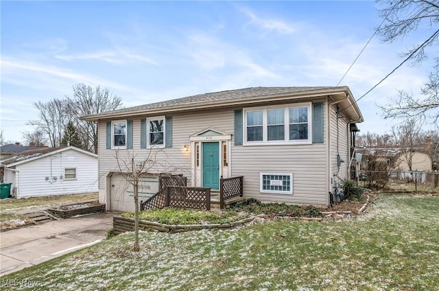 bi-level home featuring fence, driveway, and a front lawn