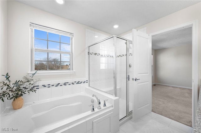 bathroom with a stall shower, baseboards, a garden tub, and recessed lighting