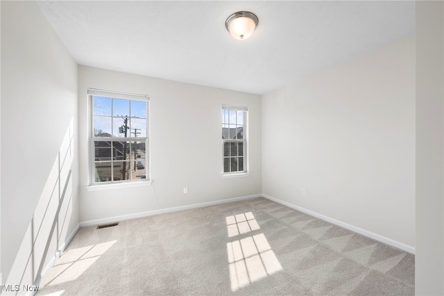 carpeted empty room with baseboards and visible vents