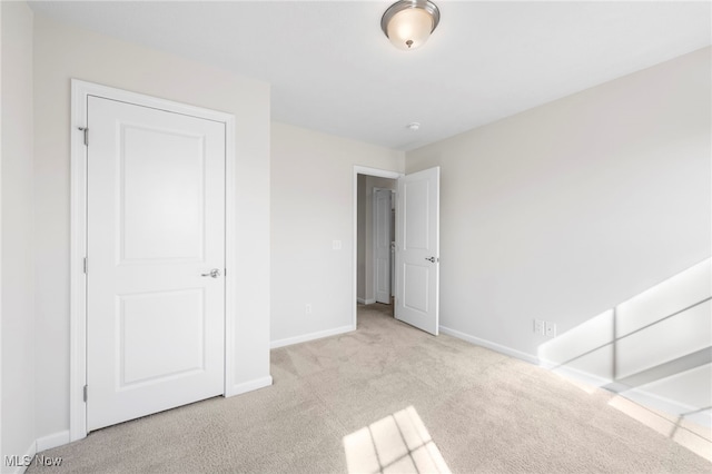 unfurnished bedroom featuring carpet and baseboards