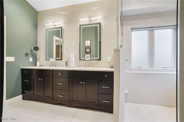 bathroom with double vanity, tile patterned flooring, and a sink