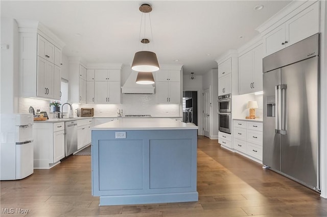 kitchen with stainless steel appliances, light countertops, dark wood-type flooring, and white cabinetry