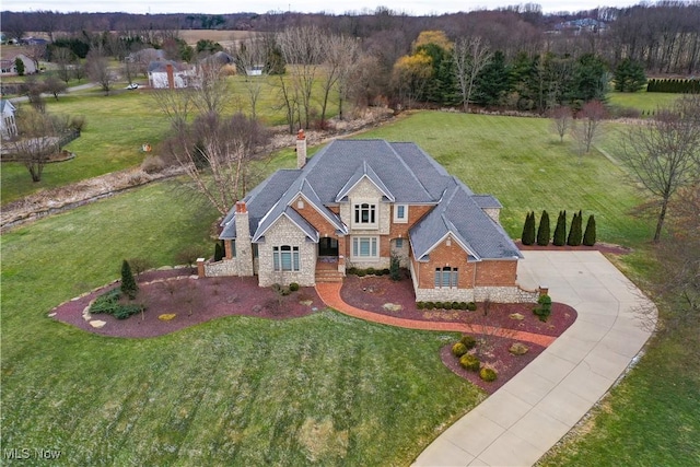 view of front of home featuring stone siding, a chimney, and a front lawn