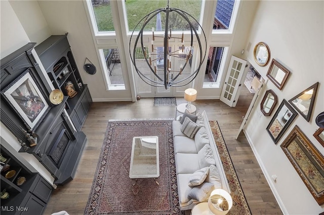 living room featuring a notable chandelier, a high ceiling, and wood finished floors