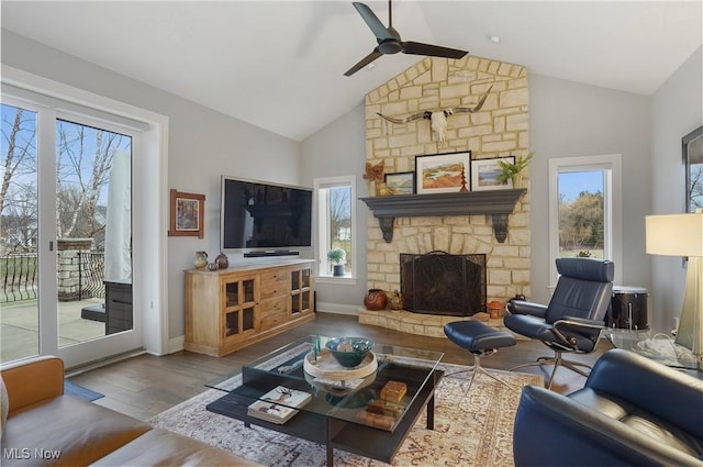 living area with ceiling fan, high vaulted ceiling, a fireplace, wood finished floors, and baseboards