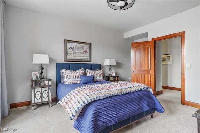 bedroom featuring light carpet and baseboards