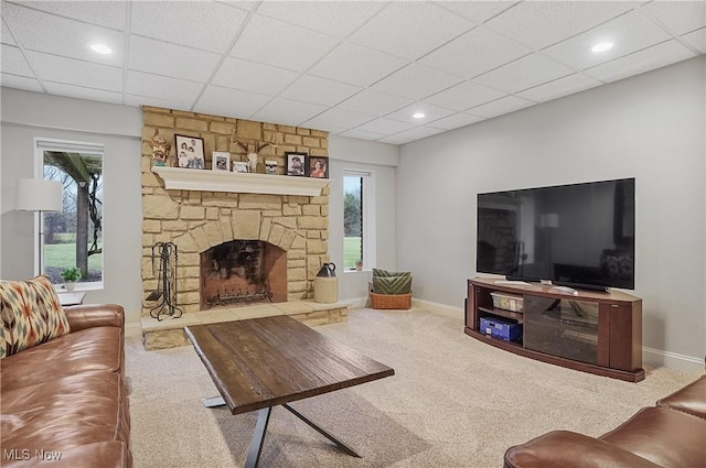 carpeted living room featuring a paneled ceiling, a fireplace, baseboards, and recessed lighting