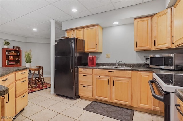 kitchen featuring electric range, a sink, freestanding refrigerator, stainless steel microwave, and dark countertops