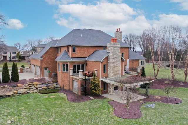 back of house featuring a garage, a lawn, a patio, a chimney, and brick siding