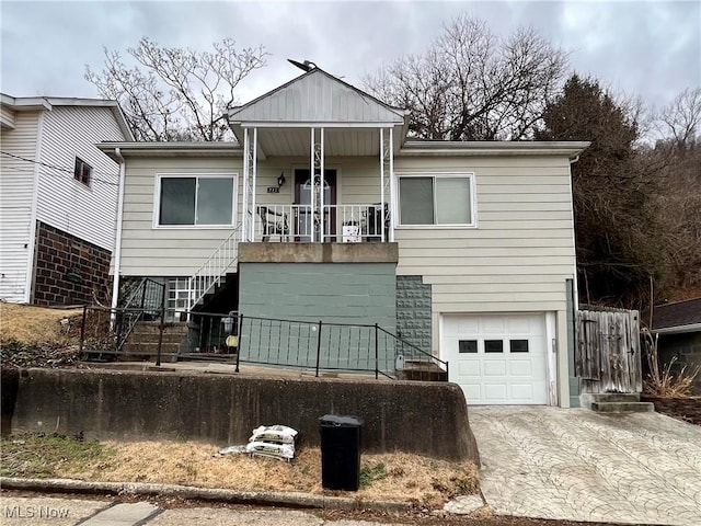 view of front of home with covered porch, driveway, stairway, and an attached garage