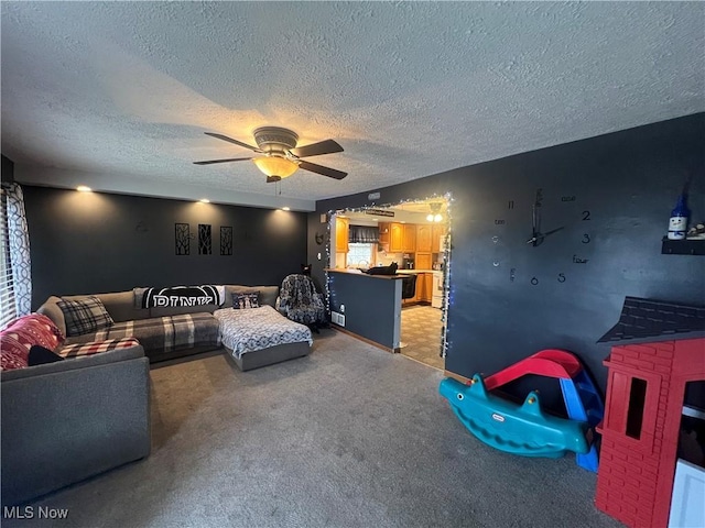 living room featuring light colored carpet, ceiling fan, and a textured ceiling
