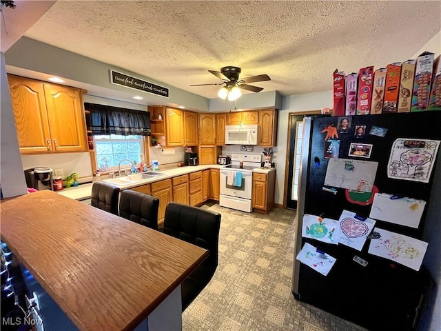 kitchen with white appliances, a sink, a ceiling fan, light countertops, and light floors