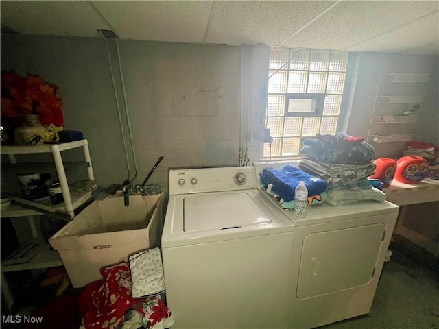 laundry area featuring laundry area, separate washer and dryer, a sink, and concrete block wall