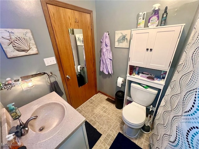 full bathroom featuring baseboards, vanity, and toilet