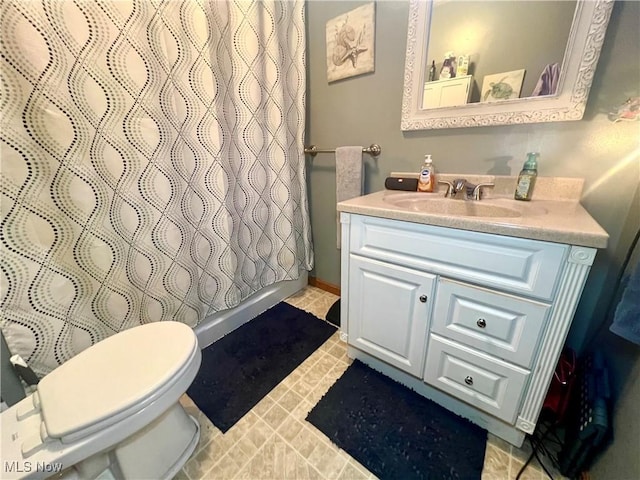 full bath with curtained shower, vanity, and toilet