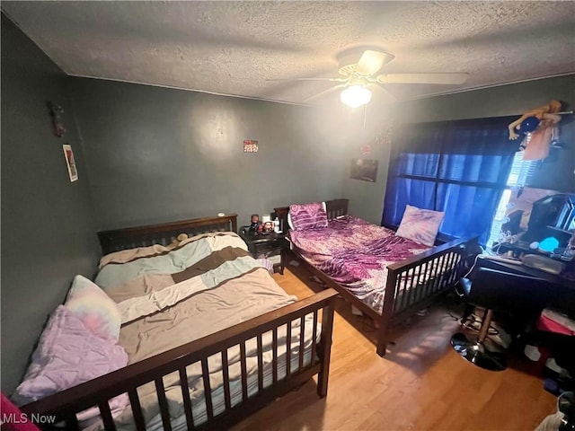 bedroom featuring ceiling fan, a textured ceiling, and wood finished floors