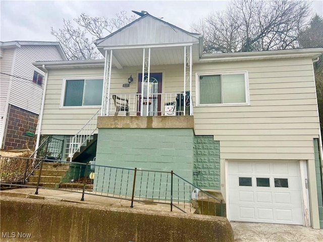 view of front facade with a garage, a porch, and stairs