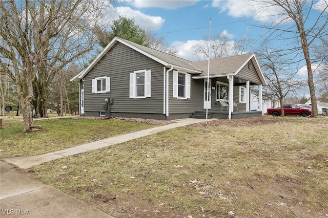 view of front of property with a porch, a front yard, and roof with shingles