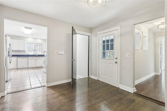 foyer entrance with plenty of natural light, baseboards, and wood finished floors