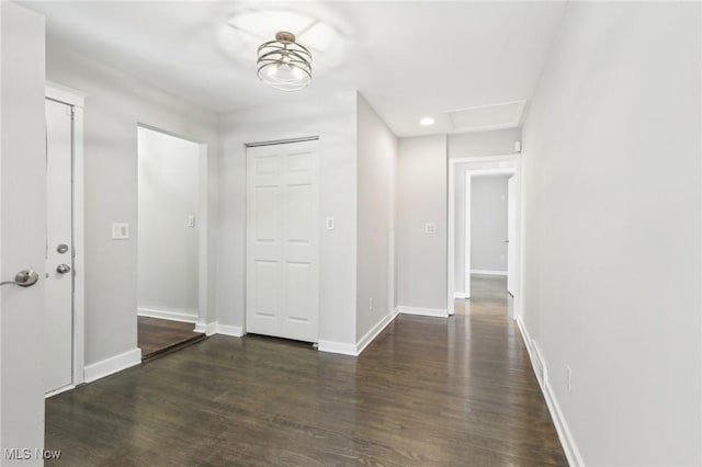 corridor with wood finished floors and baseboards