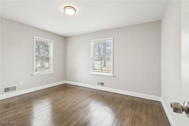 spare room with baseboards, visible vents, and a healthy amount of sunlight