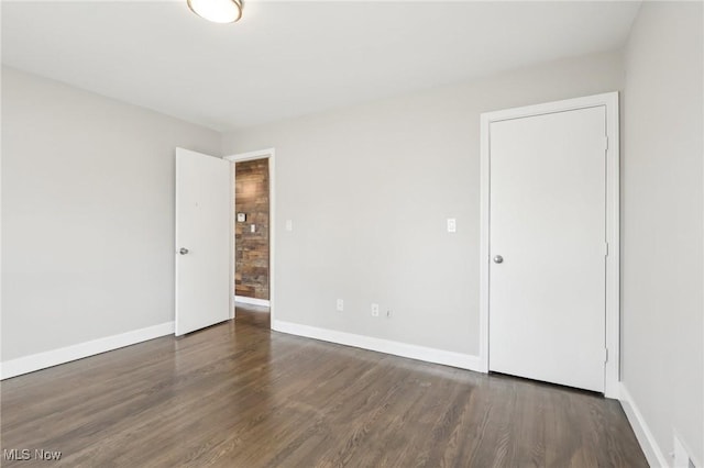 unfurnished room featuring baseboards and wood finished floors