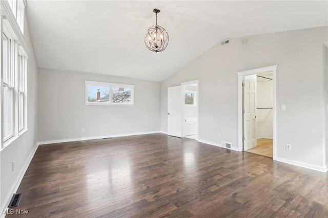 interior space featuring lofted ceiling, a notable chandelier, visible vents, and dark wood-style flooring