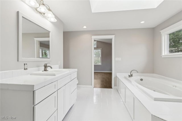 bathroom with recessed lighting, baseboards, vanity, and a whirlpool tub