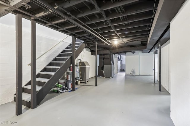 unfinished basement with water heater, stairway, and heating unit