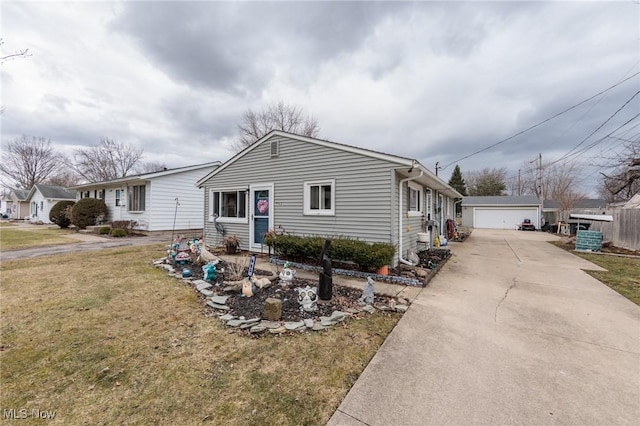 view of front of house featuring a garage, a front yard, and an outdoor structure