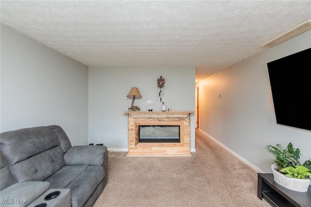 carpeted living area with a fireplace, a textured ceiling, and baseboards