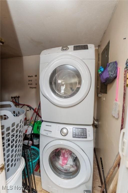 clothes washing area with stacked washer and dryer and laundry area