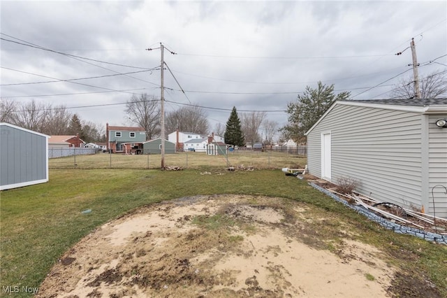 view of yard with a storage shed, an outdoor structure, and fence