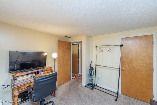 office with a textured ceiling, visible vents, and carpet flooring